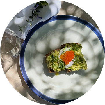 Servizio di brunch presentato con un piatto con crostone di pane integrale, guacamole, uovo sodo, caviale e erba cipollina, piatto del ristorante da Alcide a Venturina, in Toscana.