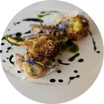 Servizio del ristorante presentato con un fotografia do un piatto di calamari, carciofi e salsa all'aceto balsamico, piatto del ristorante da Alcide a Venturina, in Toscana.