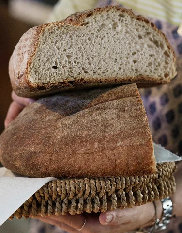 Due parti sovrapposte di una grande pagnotta di pane fatto con farine integrali dalla cucina del ristorante da Alcide a Venturina, in Toscana.